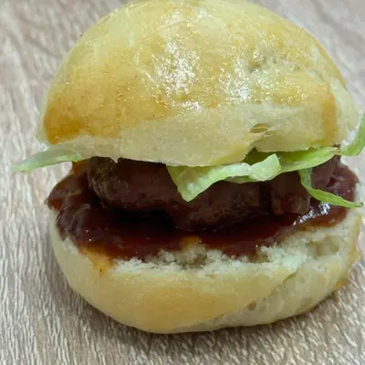 Мини BBQ бургер с телешко кюфте, тъмен сос и свежа салата в мека питка.